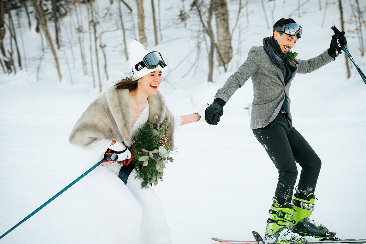 bride and groom skiing down killington mountain in vermont at adventure elopement in winter