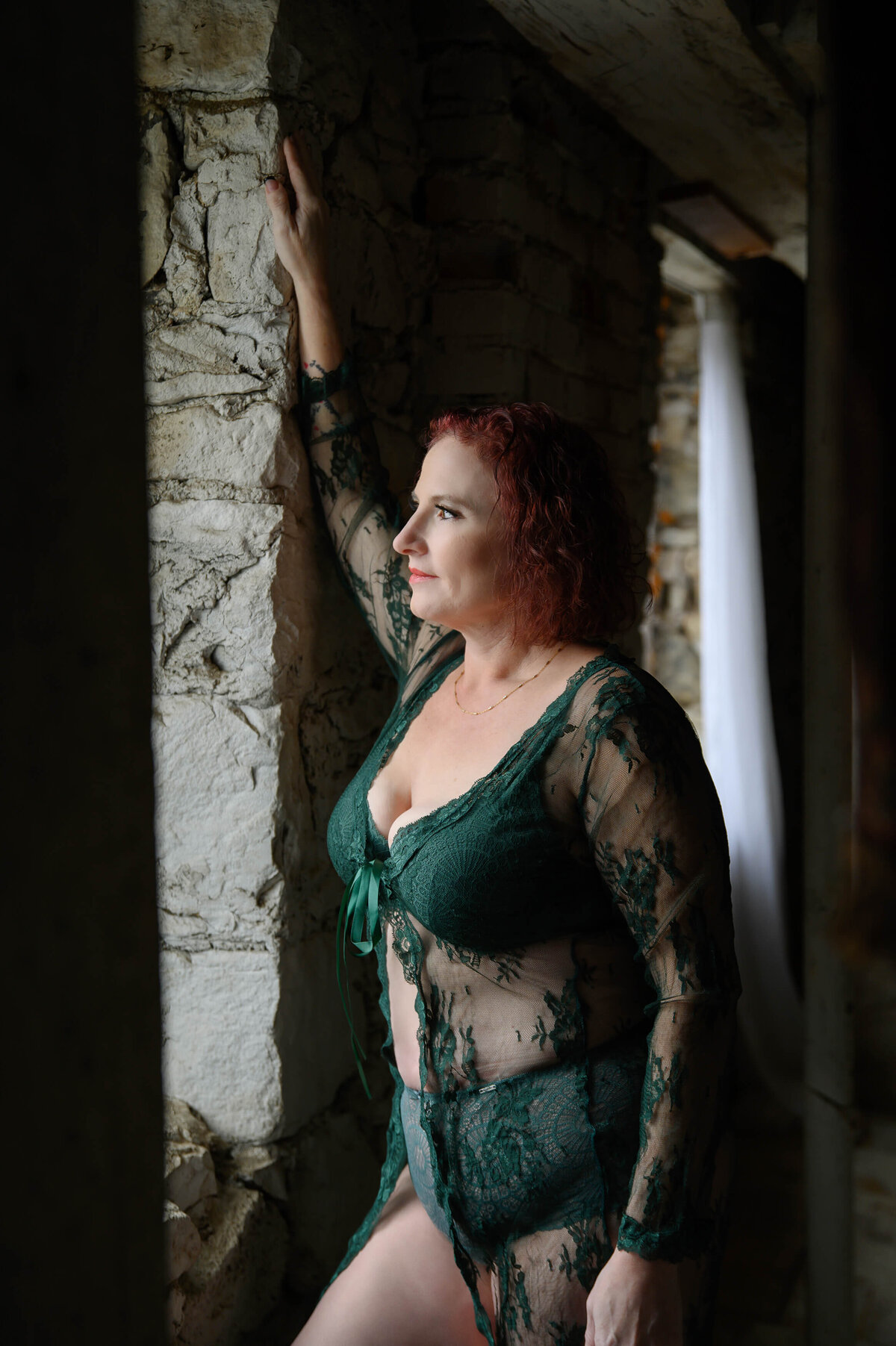 Woman in green bra and underwear with her hand against a brick wall for her Mississauga  boudoir photography session