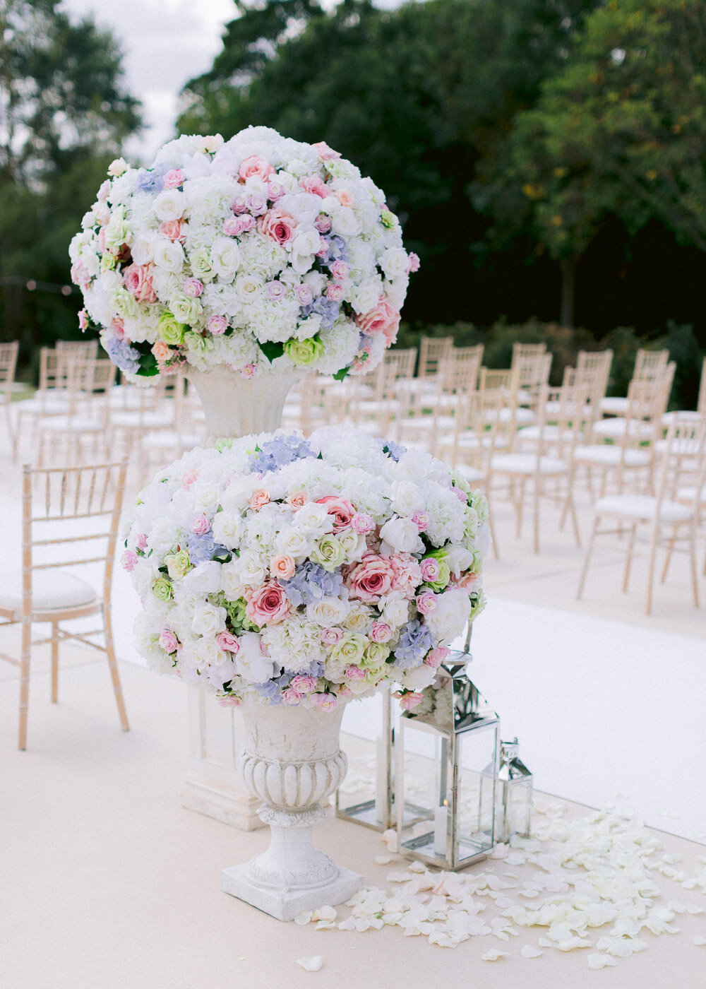 two luxury large artificial mixed colour round ball flower arrangements and candle lanterns for outdoor wedding ceremony