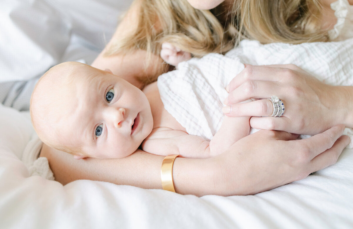 Newborn Baby wrapped in a blanket looking at the camera