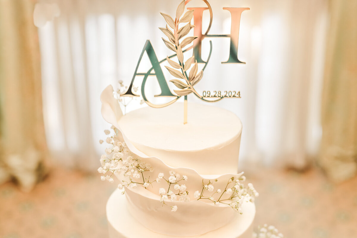 A cream wedding cake with cream piping around it by JoLynn Photography