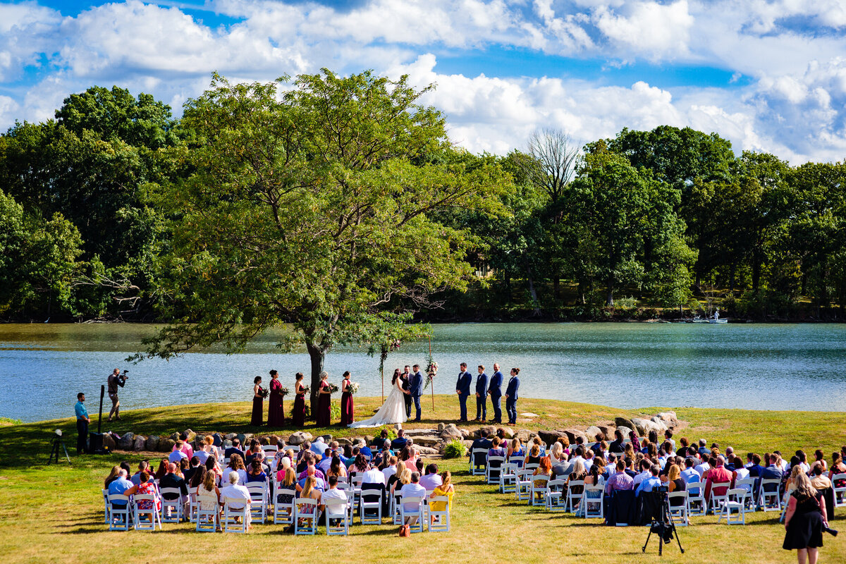 One of the top wedding photos of 2020. Taken by Adore Wedding Photography- Toledo, Ohio Wedding Photographers. This photo is of an outdoor wedding ceremony on the water in TOledo Ohio