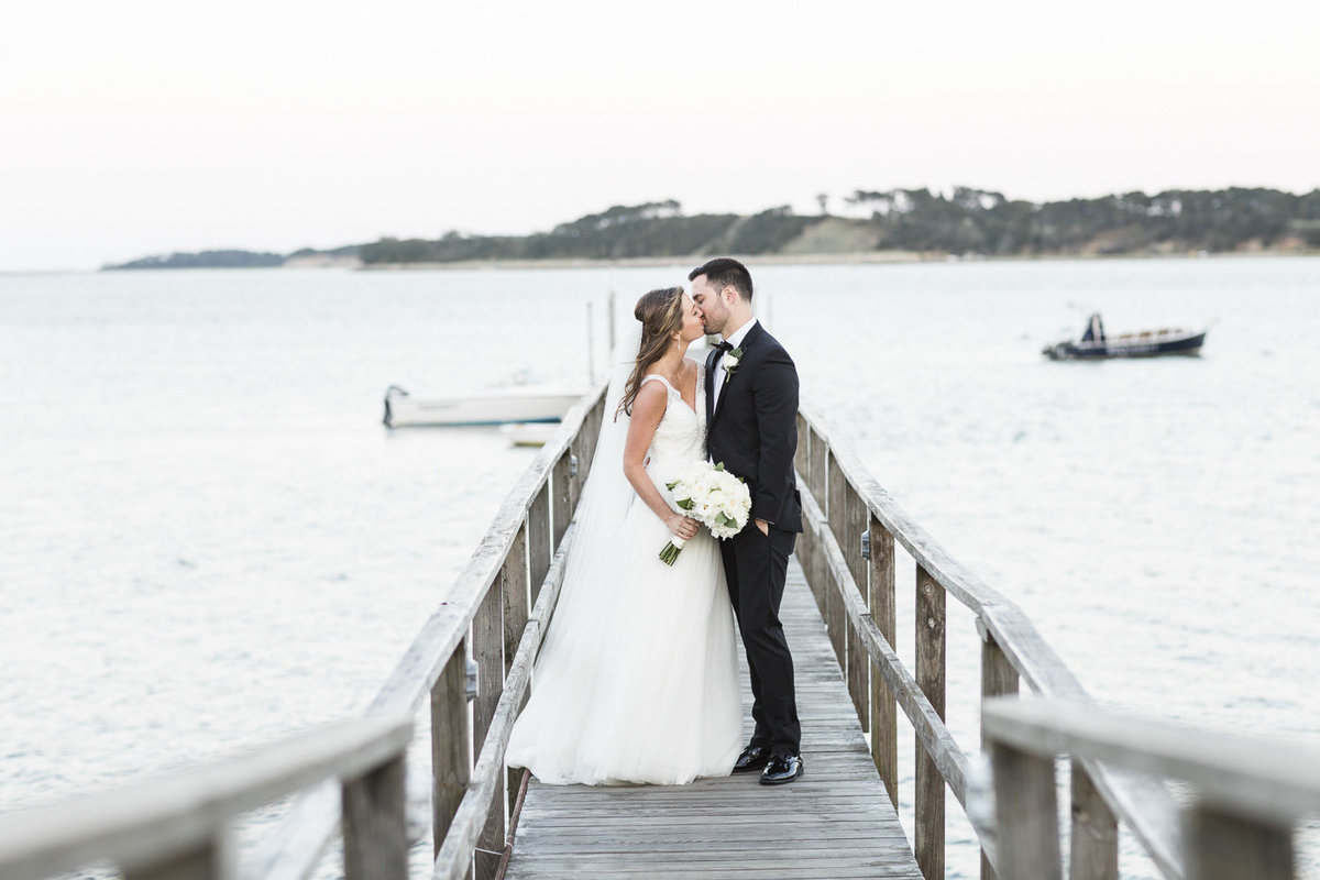 bride and groom kissing on bridge at Wequassett Resort