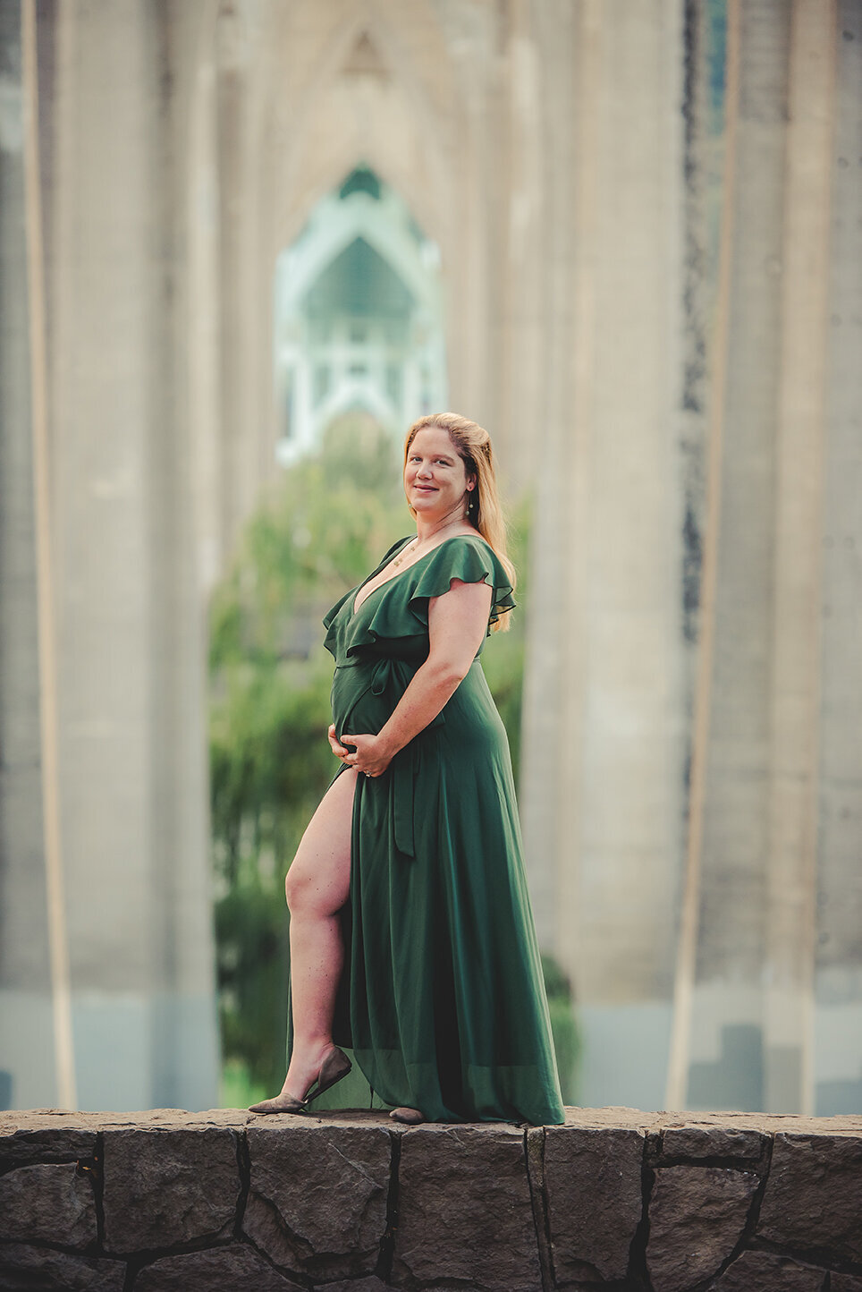 pregnant woman posing under bridge