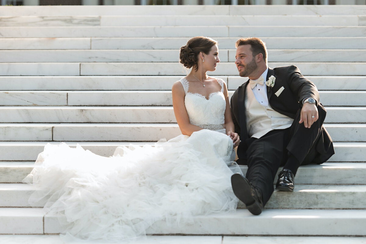 bride and groom sitting on the steps at de Seversky Mansion