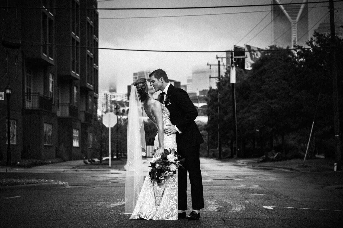 A couple kissing in the middle of the street.