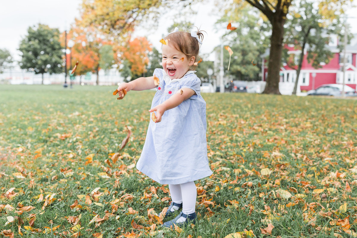 Toddler Girl throwing leaves in the air