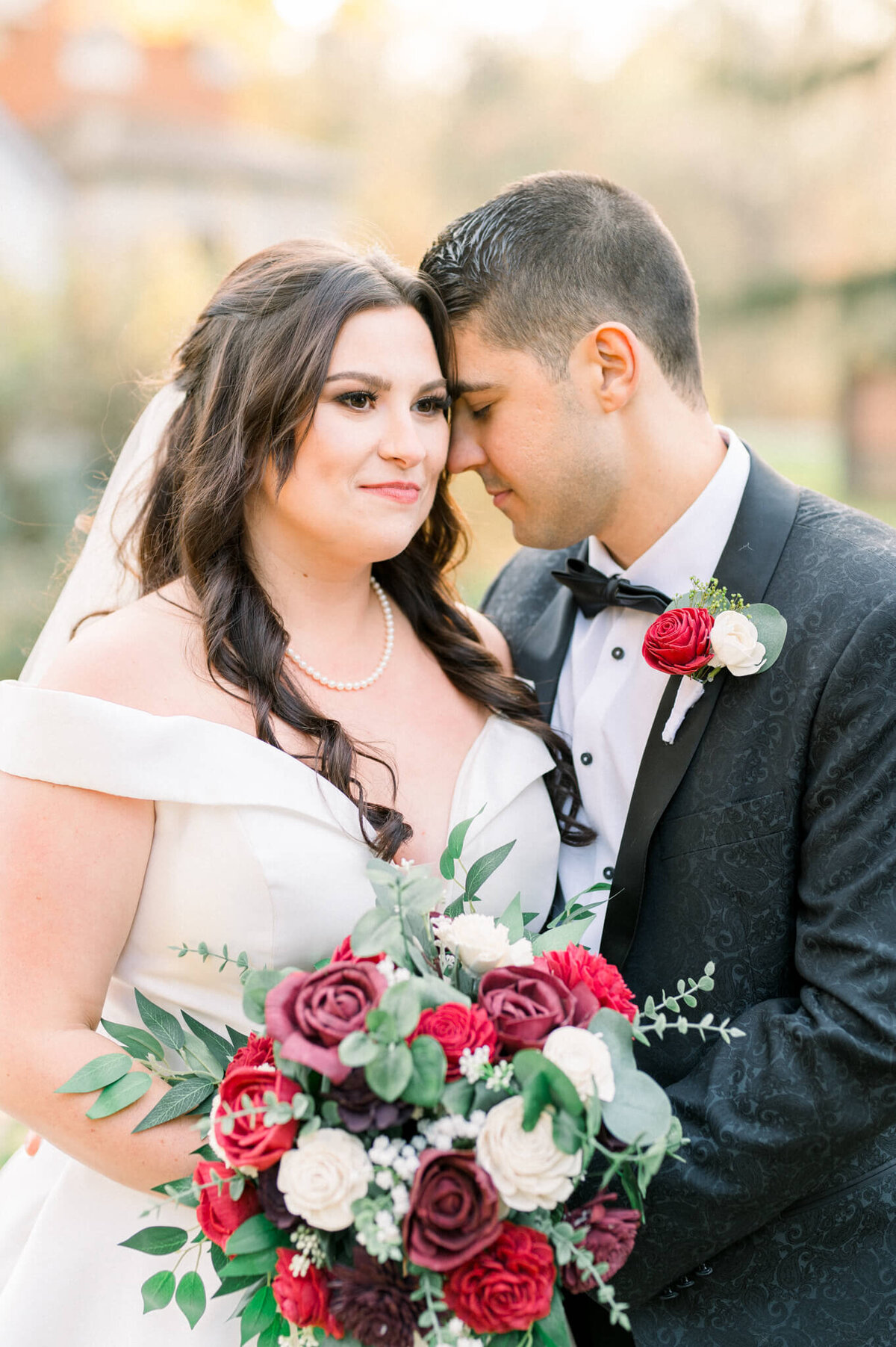 Bride and groom snuggle close for wedding portrait