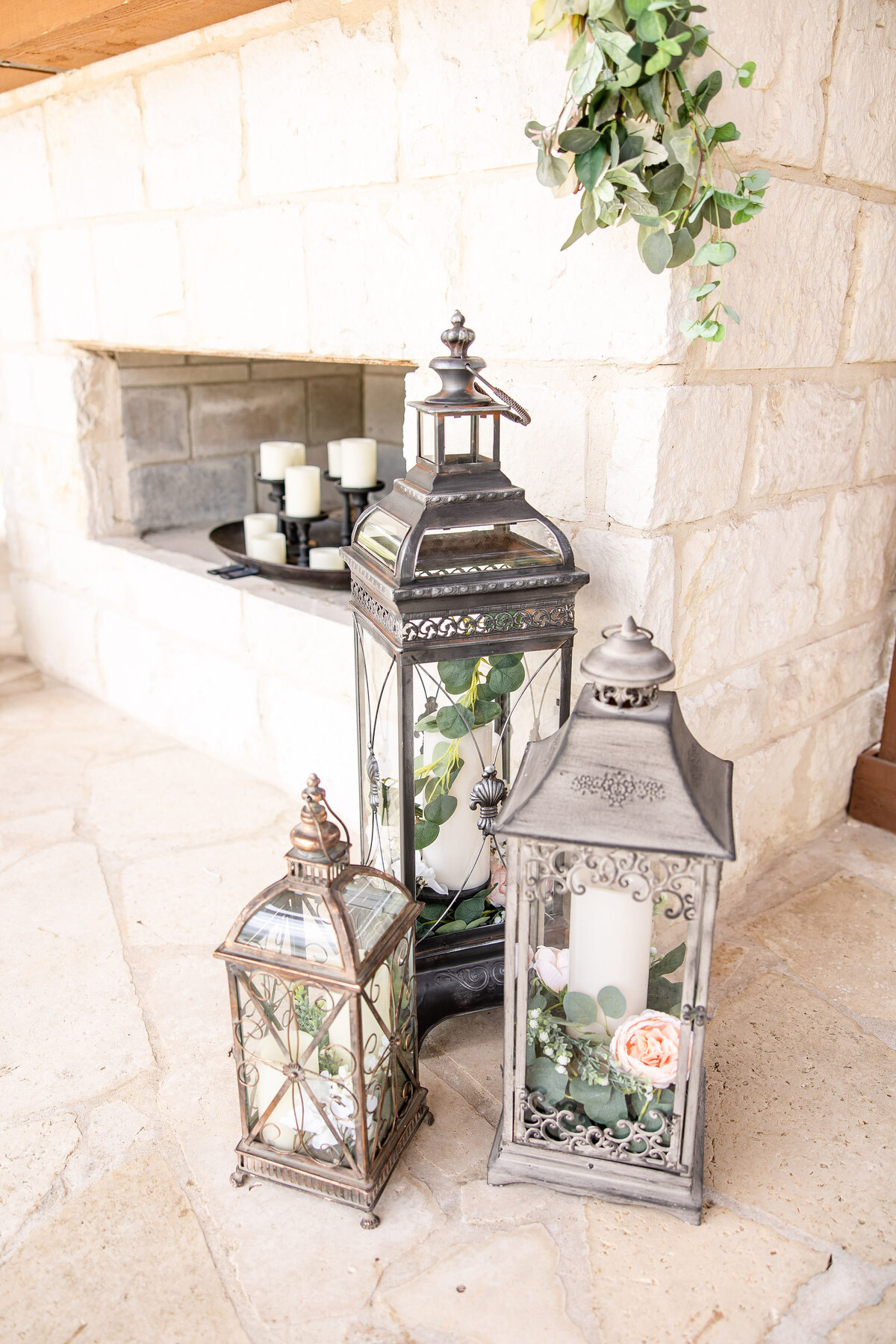 wedding photographer in Texas captures 3 vintage lanterns by fireplace at ceremony site Milestone New Braunfels Texas