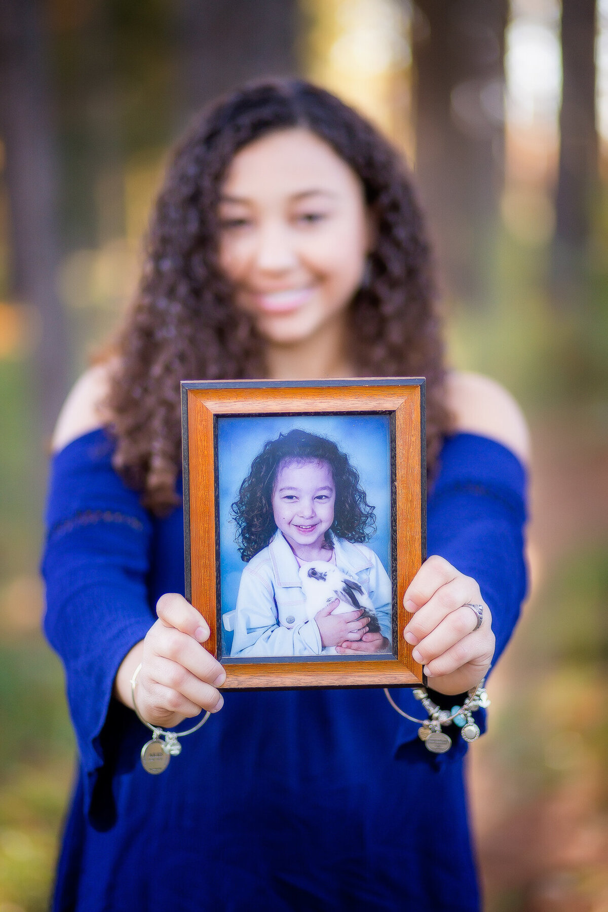 Color image of girl in a blue dress holding an image of herself