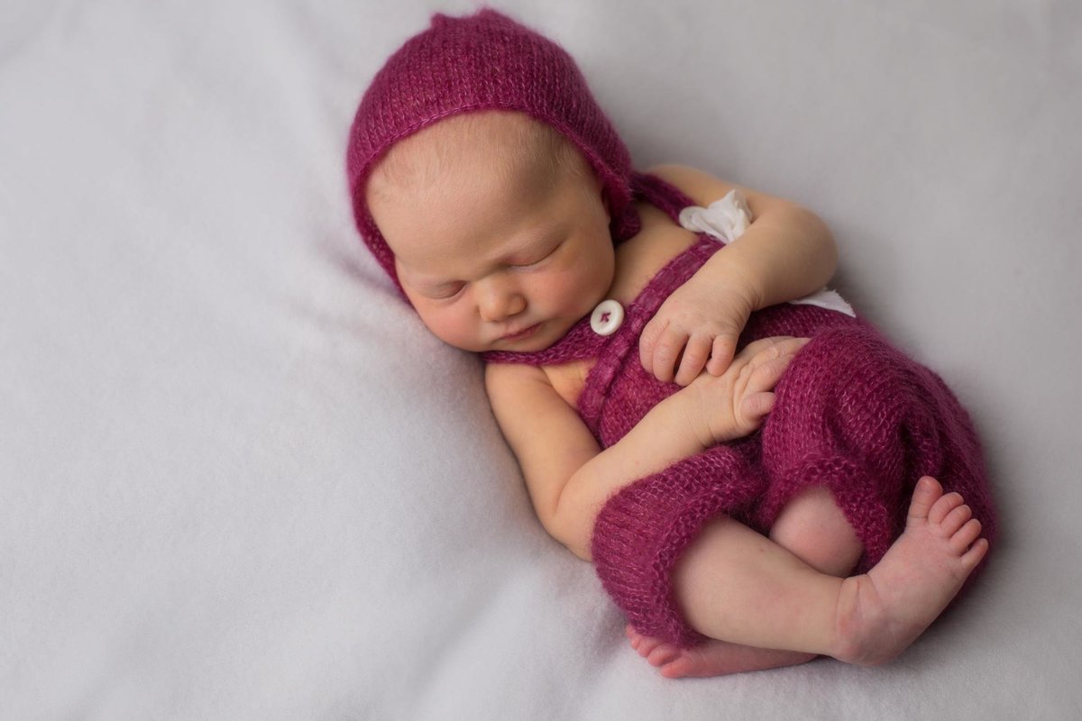 newborn baby girl in matching outfit and bonnet