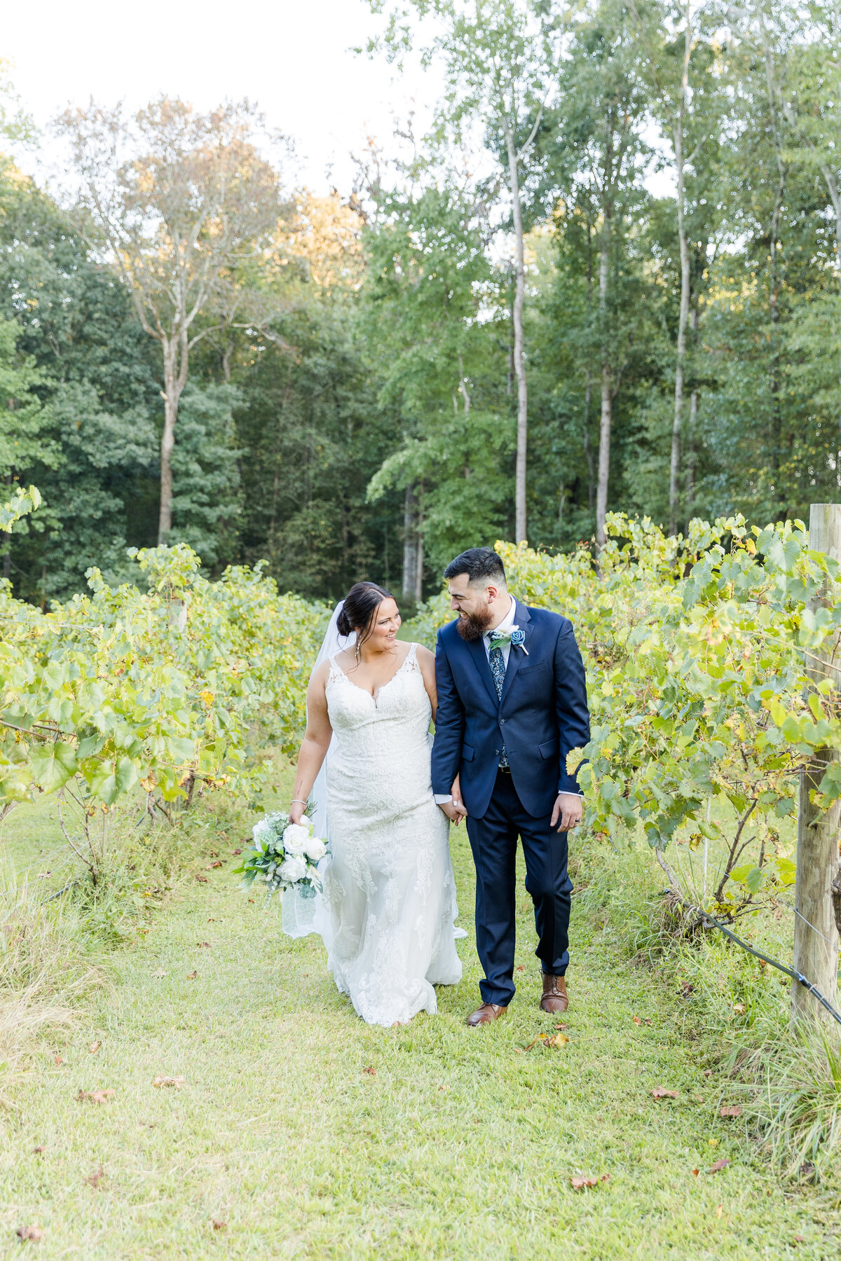 bride and groom walking amongst the vineyards