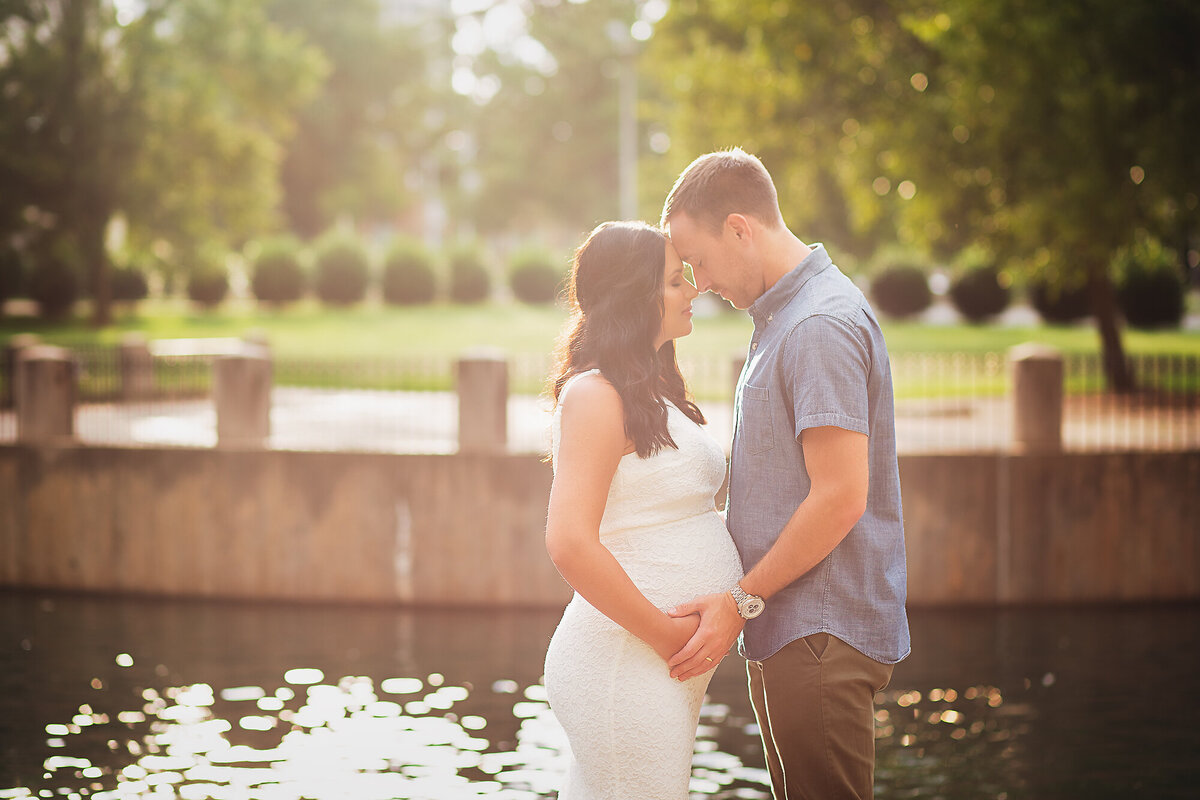 couple gazing in eyes hands on pregnant belly