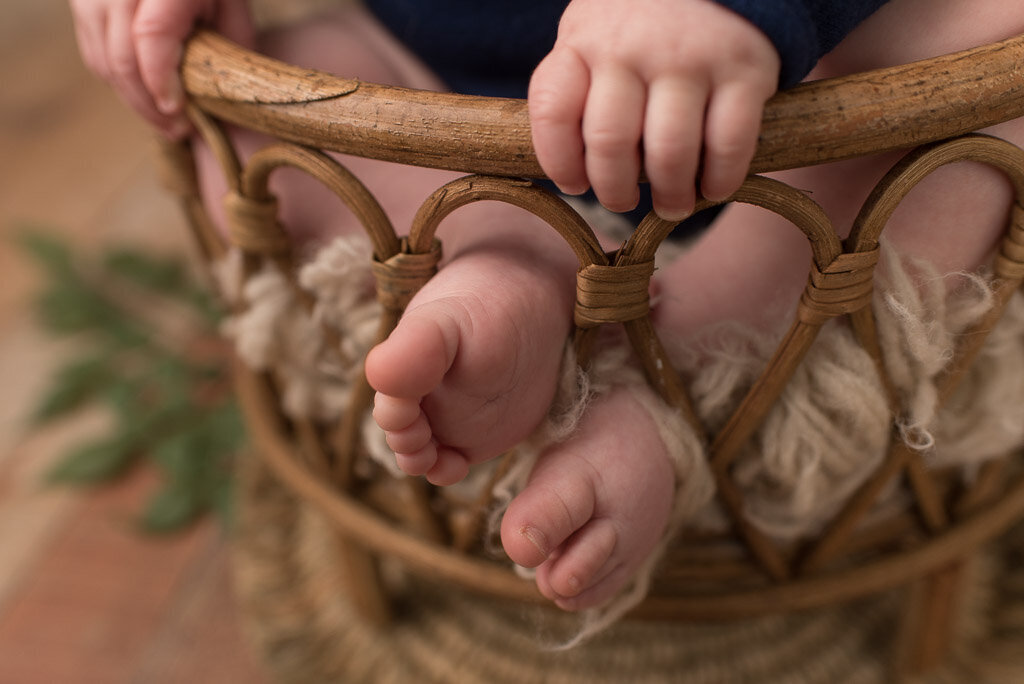 Little boy feet sticking out of the rungs of a basket