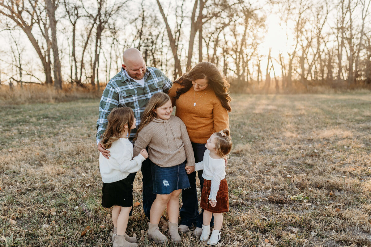 Family with 3 girls are looking at each other and smiling