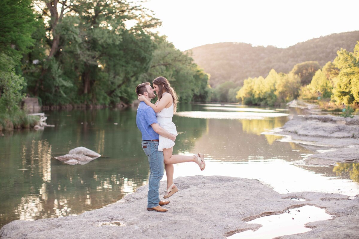 New Braunfels Texas wedding engagement session on river man lifts woman in kiss at sunset by Firefly Photography
