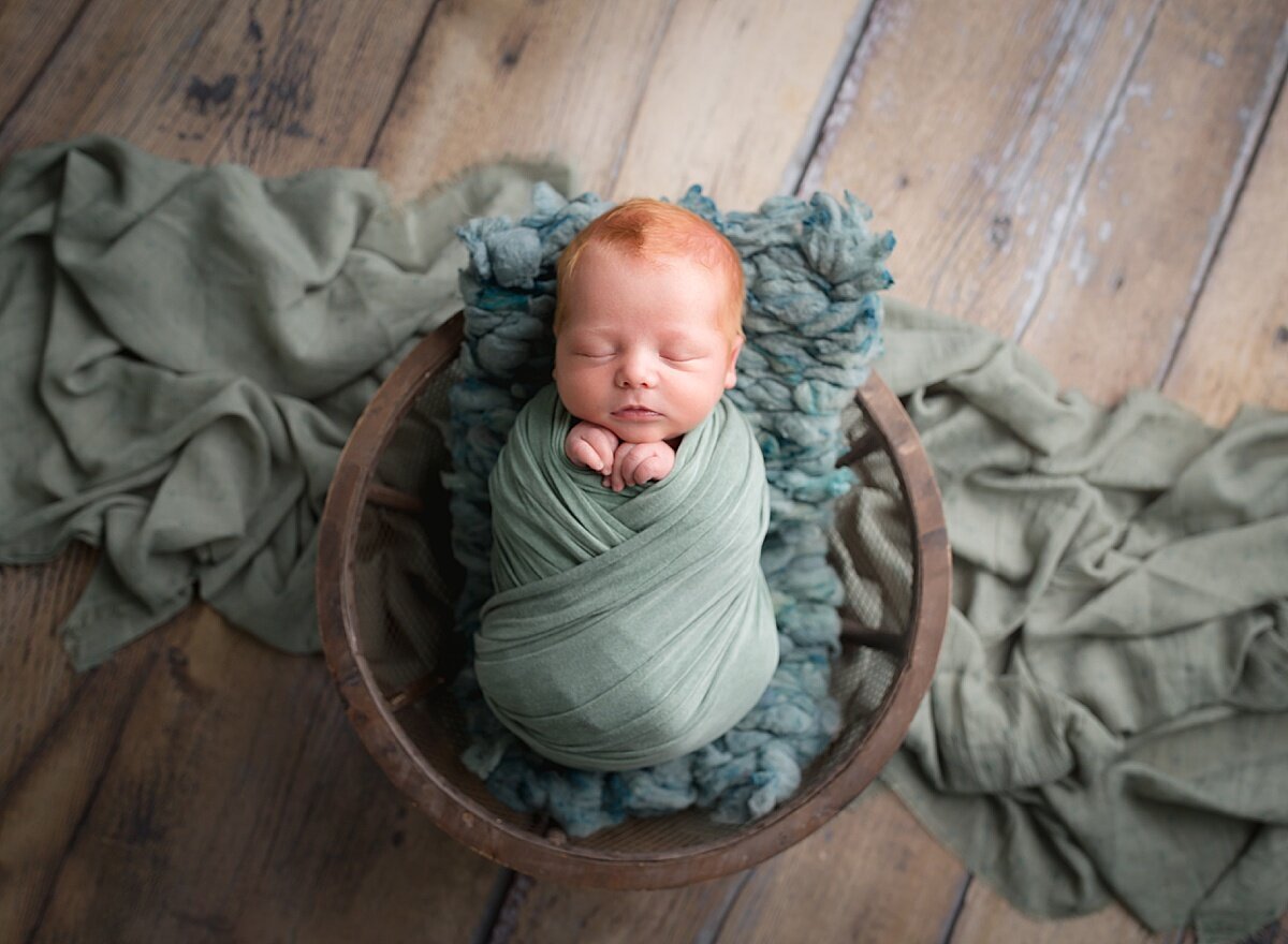 A red-headed baby in a bowl. Photo by Diane Owen Photography.