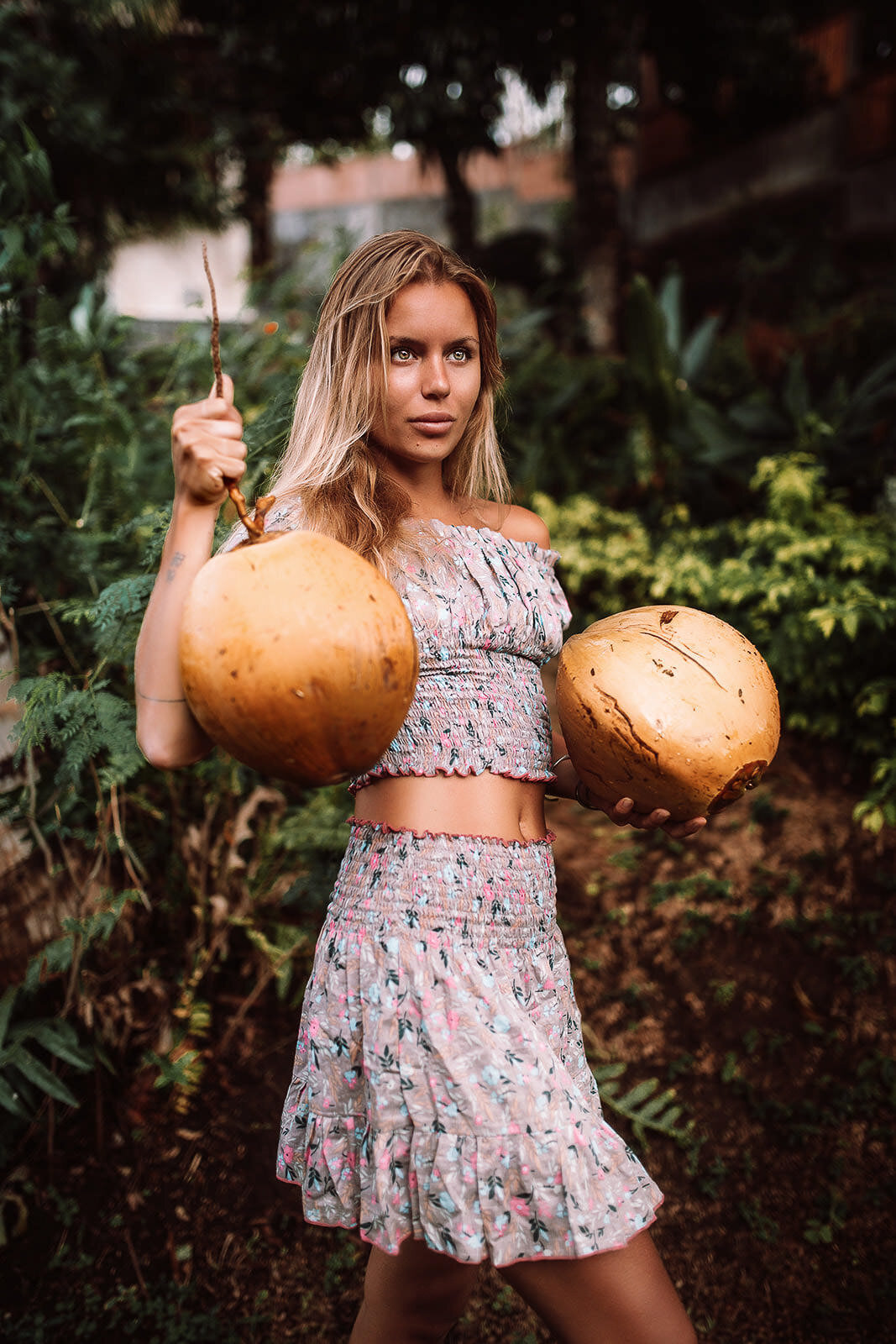 blonde girl in bali picking coconuts