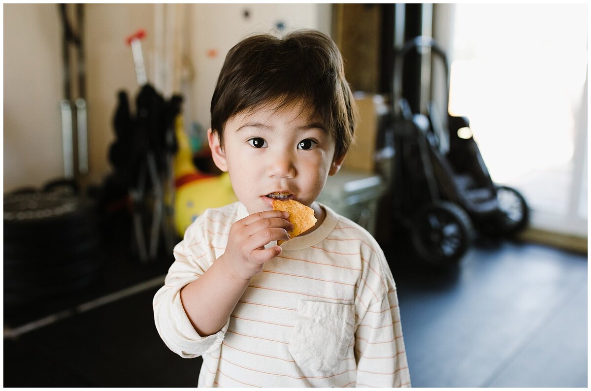 Child eating piece of fruit at family photo session in Austin by Amber Vickey Photography