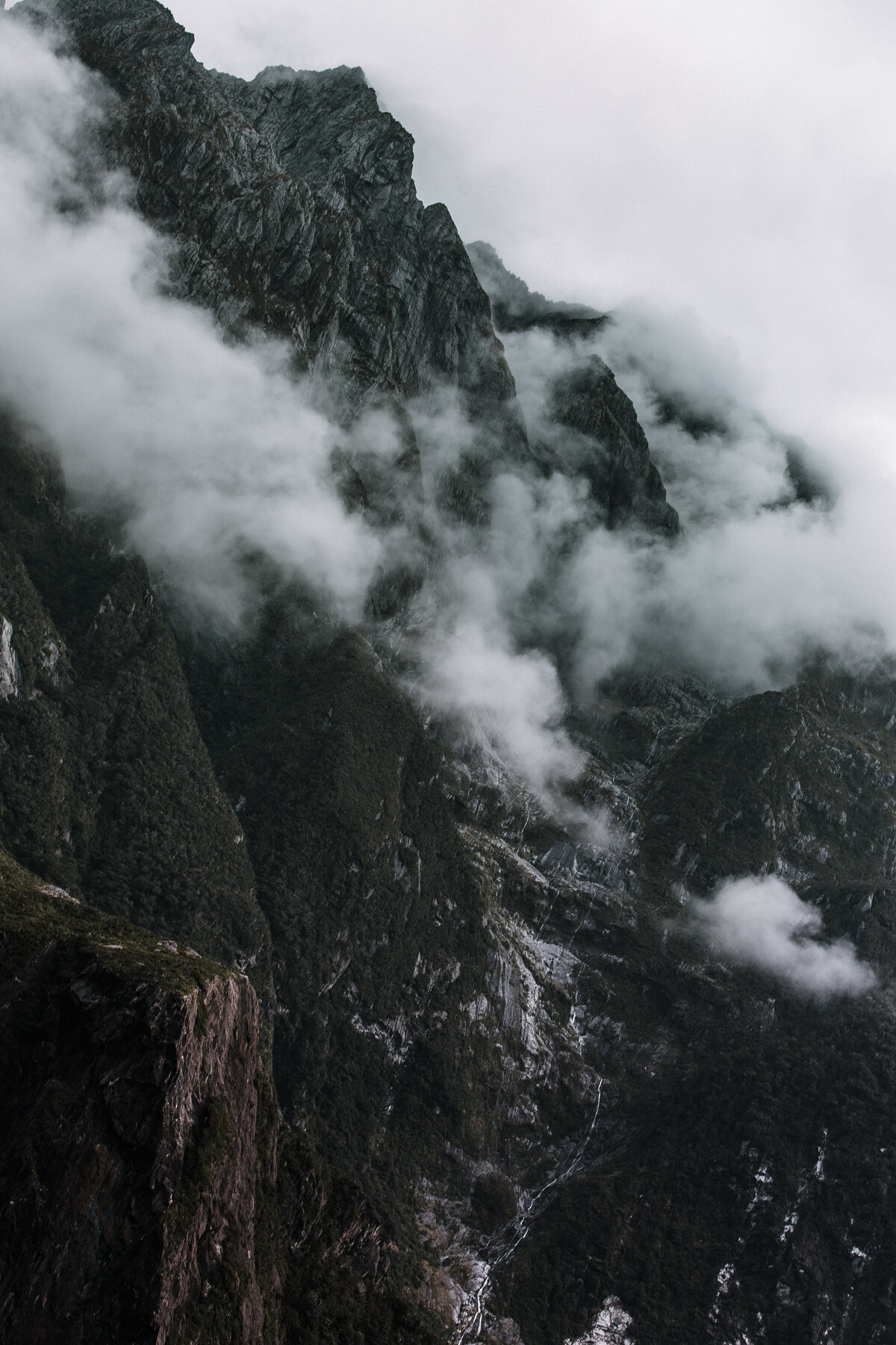 Mountain peaks through fog in Milford Sound, New Zealand