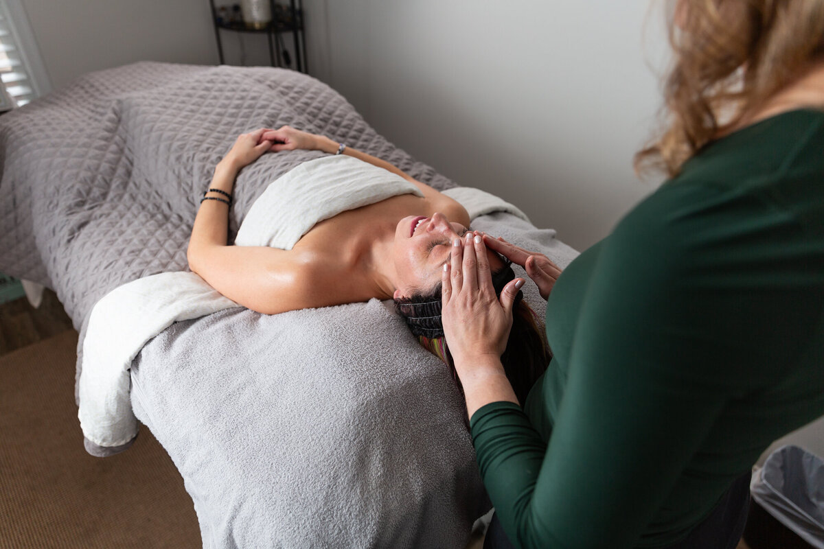 Client-lays-on-bed-during-branding-phoshoot-with-esthetician-and-photographer-Ingrid-Berrios-in-Baltimore