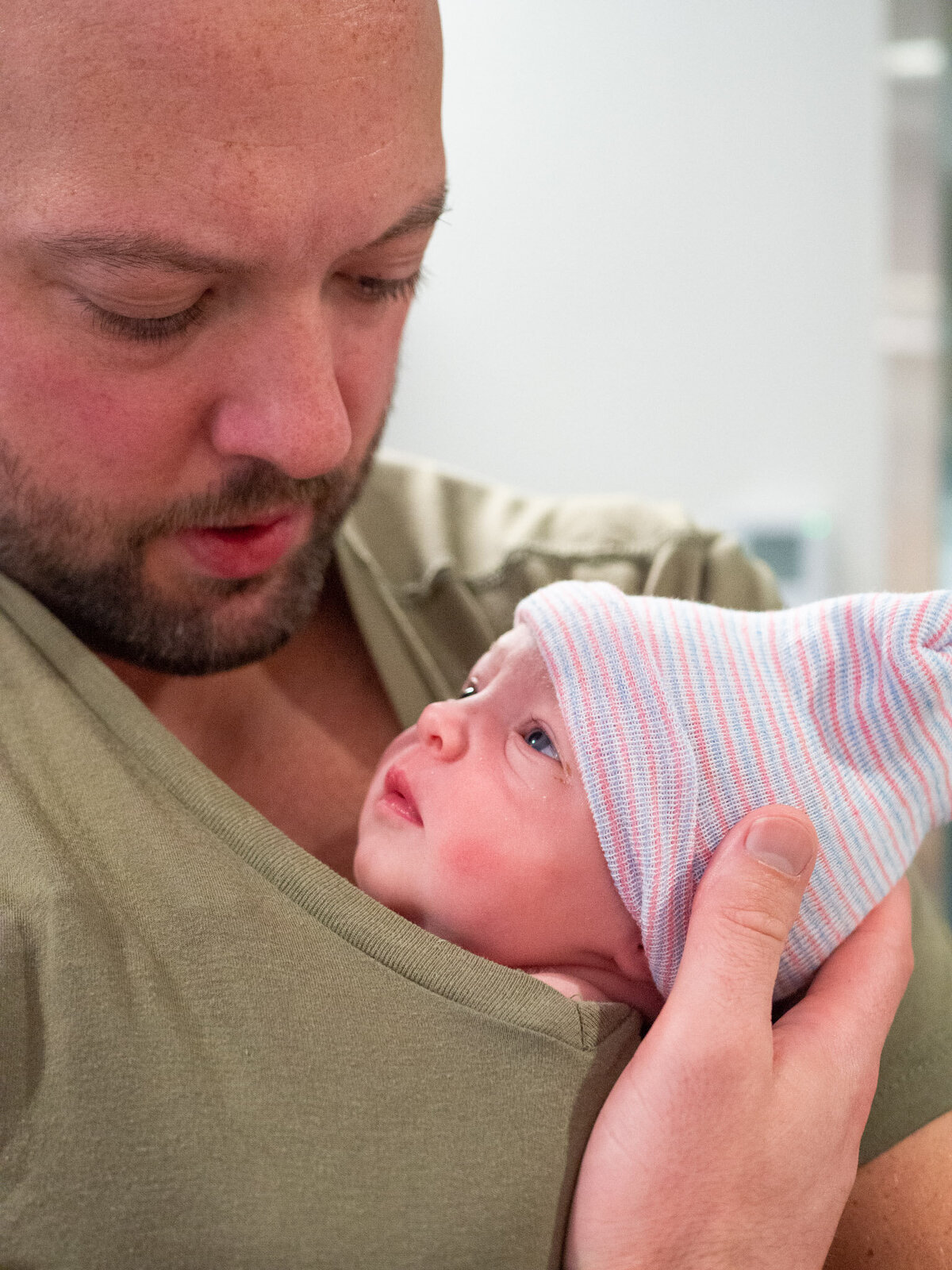 a brand new father is doing skin-to-skin with his new baby daughter.