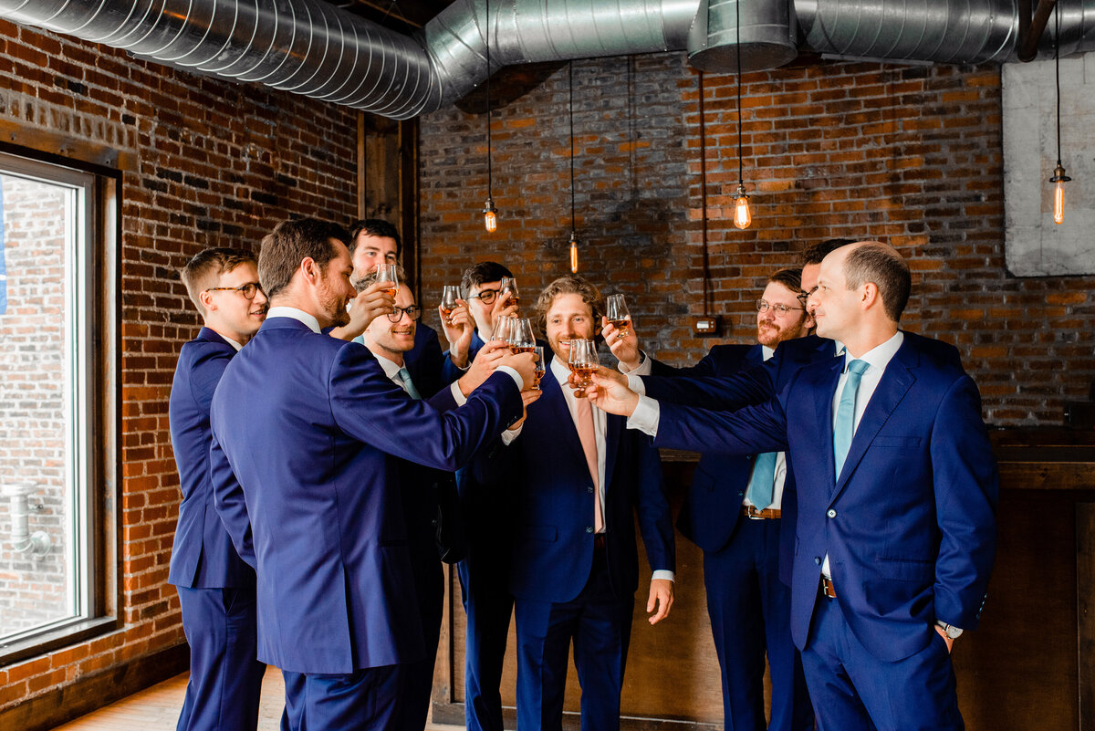 Groom sharing a bourbon toast with his groomsmen