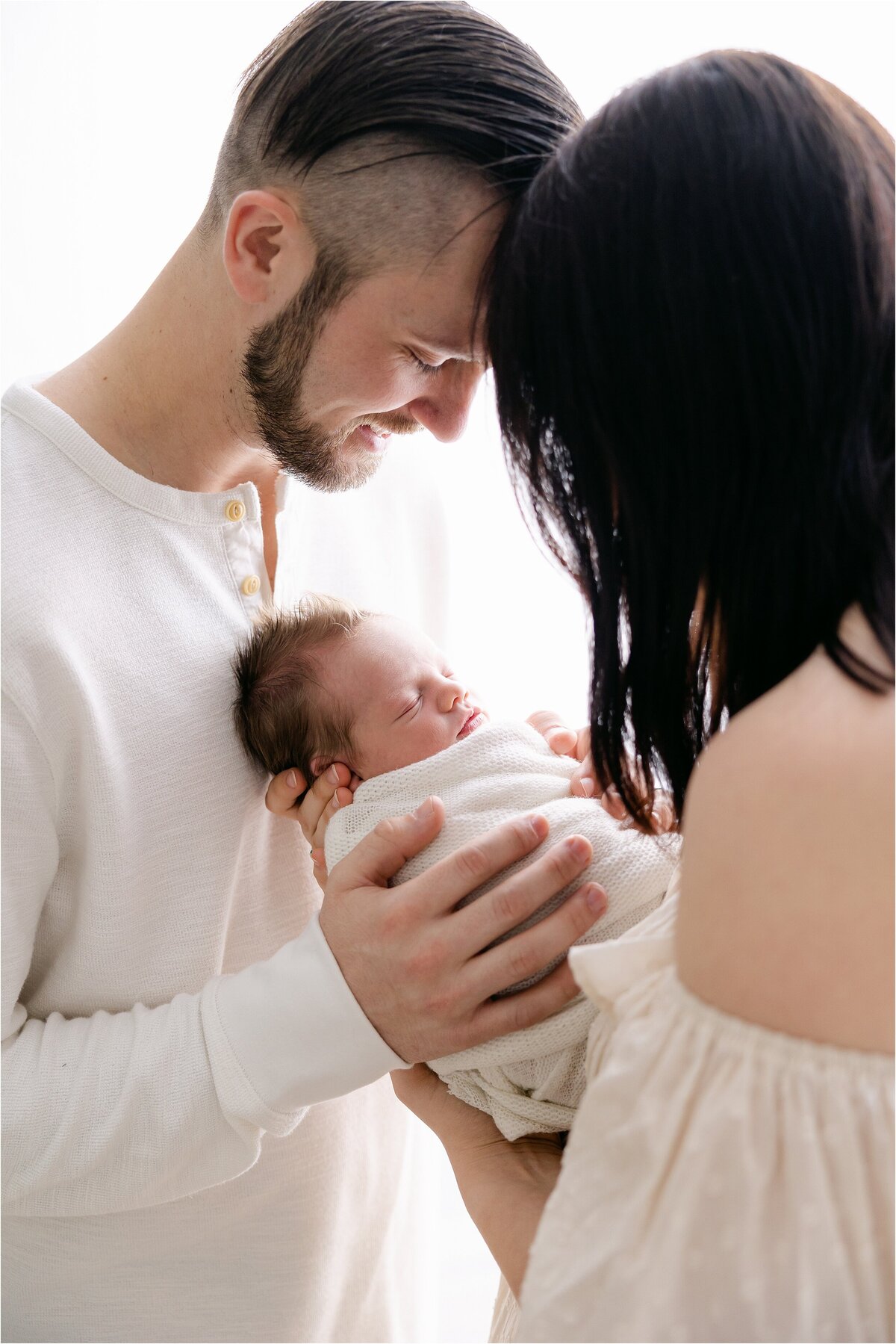 new parents looking lovingly at their baby boy during newborn session