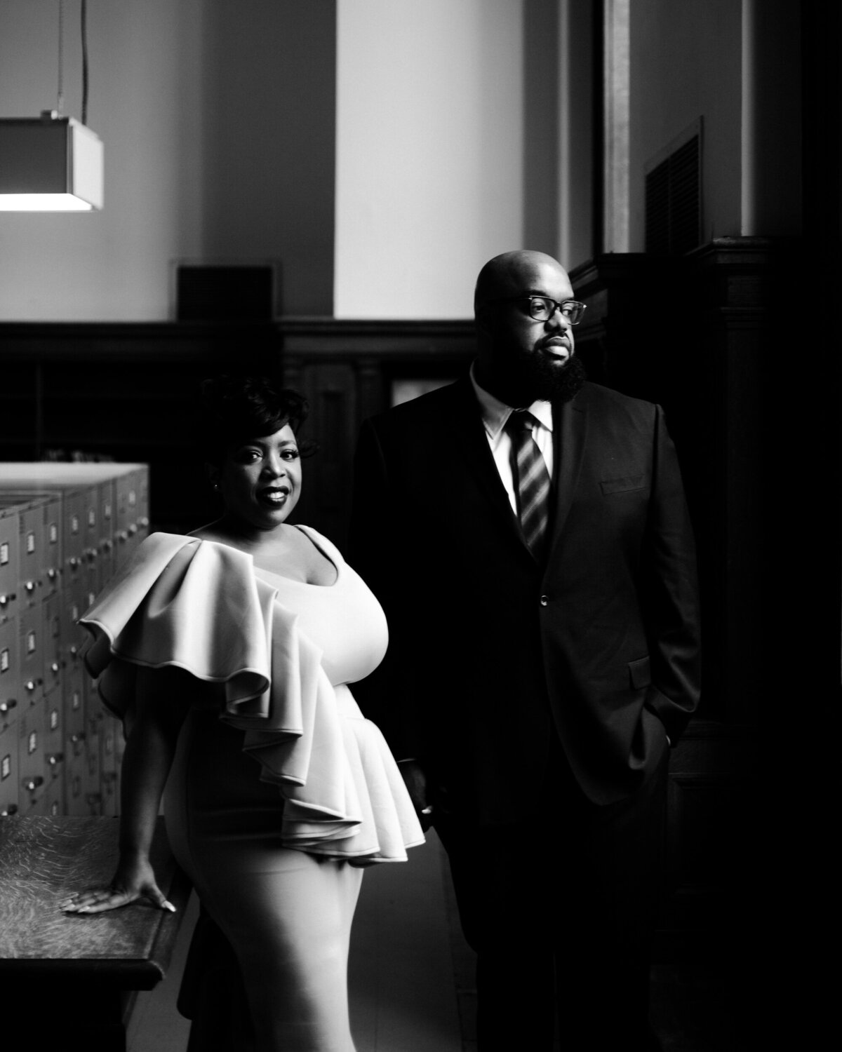 Classy engagement photo at the Detroit Public Library. A black and white photograph that shows off the couples attire.  Photo By Adore Wedding Photography. Toledo Wedding Photographers