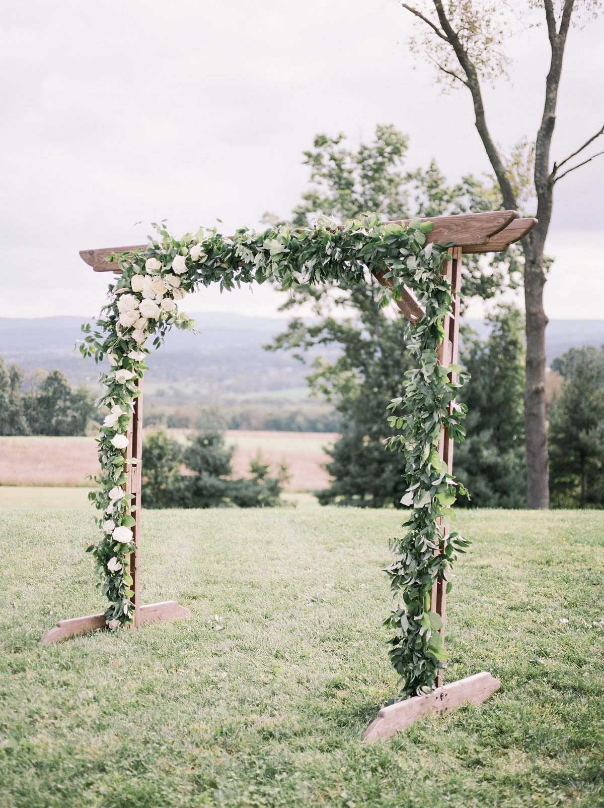 wooden alter with greenery and white roses at philadelphia outdoor wedding