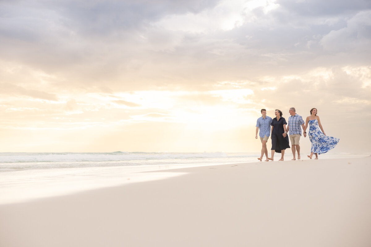 A family walking along the beach at sunset.