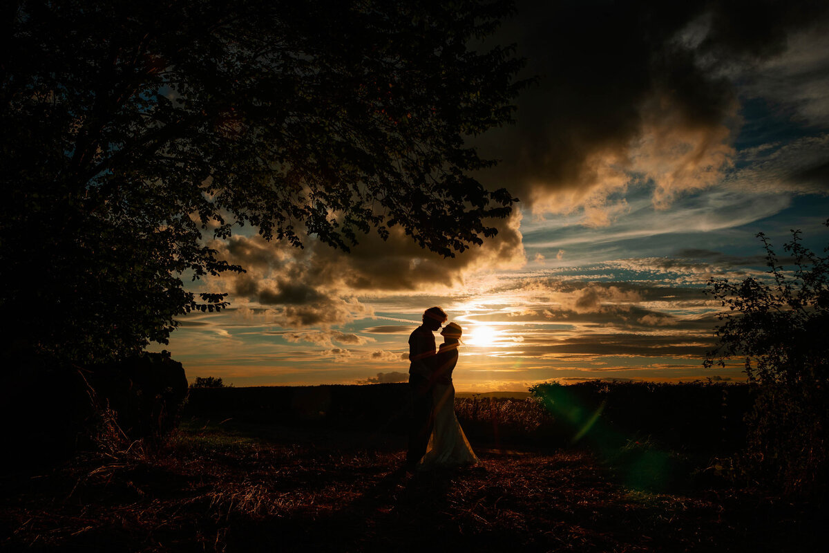 silhouette of a couple at sunset at their small home wedding
