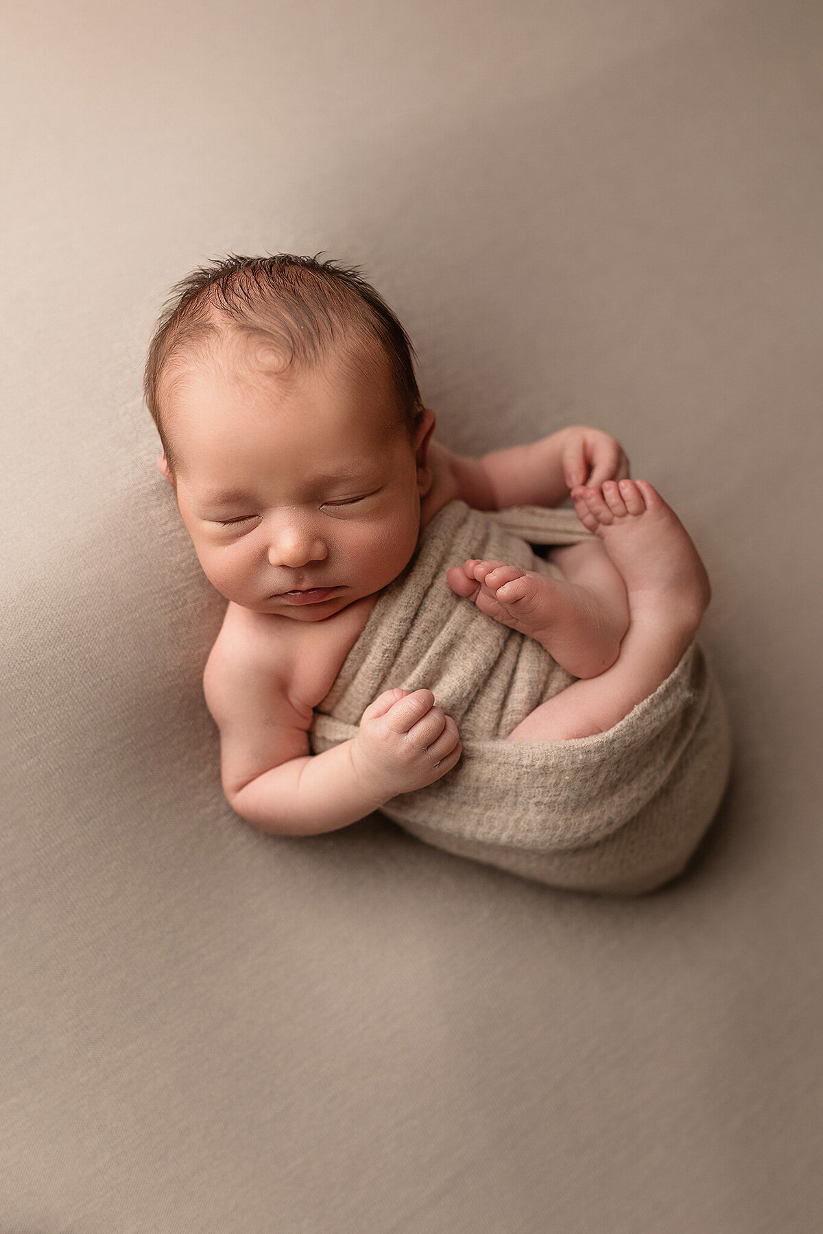 Baby boy on tan wrapped up for his newborn session with Jennifer Brandes.
