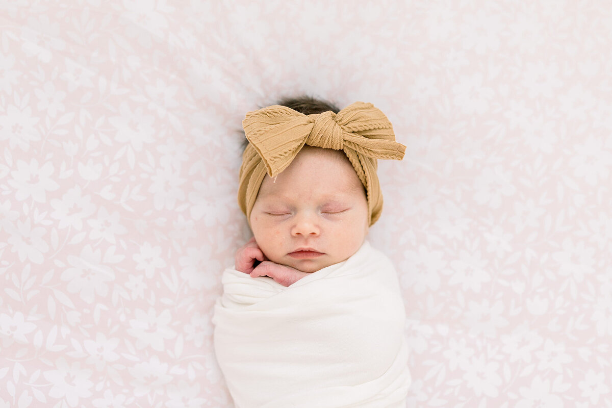 Baby girl with bow in a swaddle