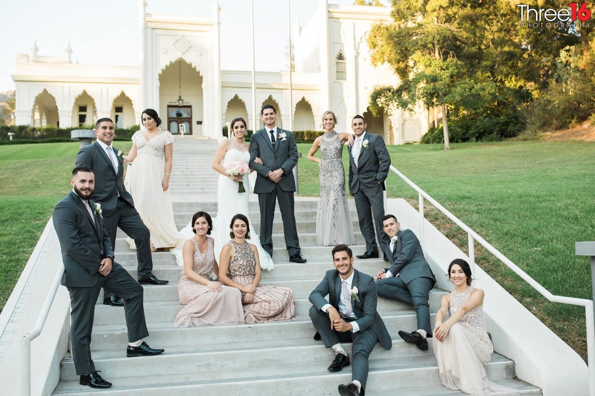 Bride and Groom pose with their wedding party on the steps at the Brand Library Park in Glendale, CA