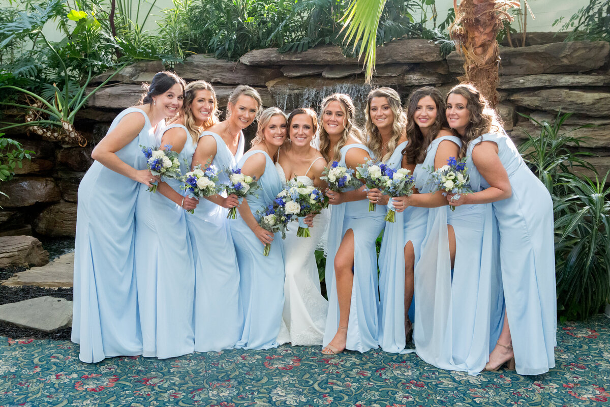 Bridesmaids in light blue pose with bride in white dress New York wedding photographer Milestone Images