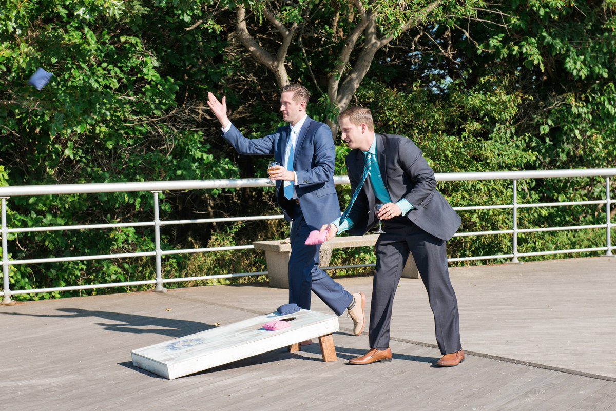 photo of groomsmen playing bag toss during wedding reception at Pavilion at Sunken Meadow