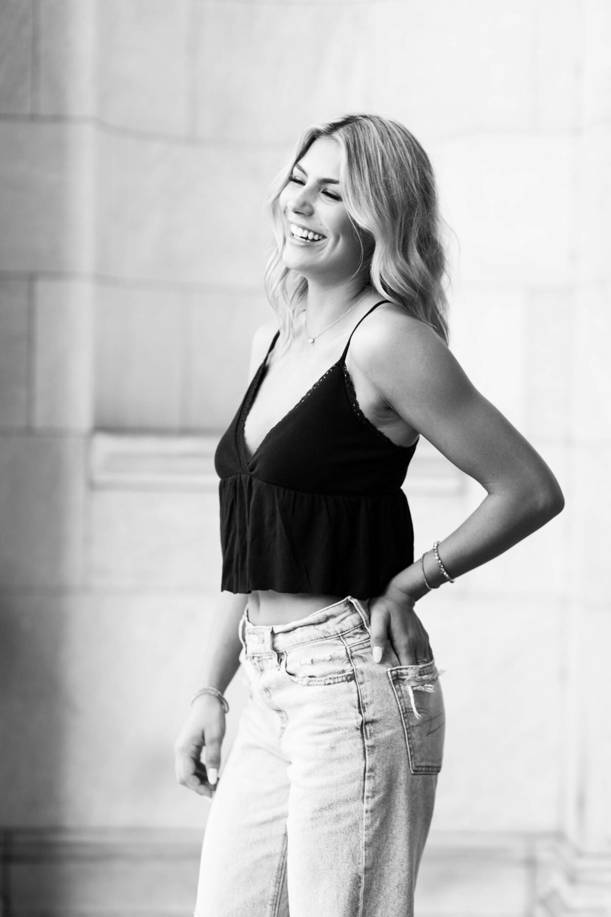 girl with hand in her pocket laughing