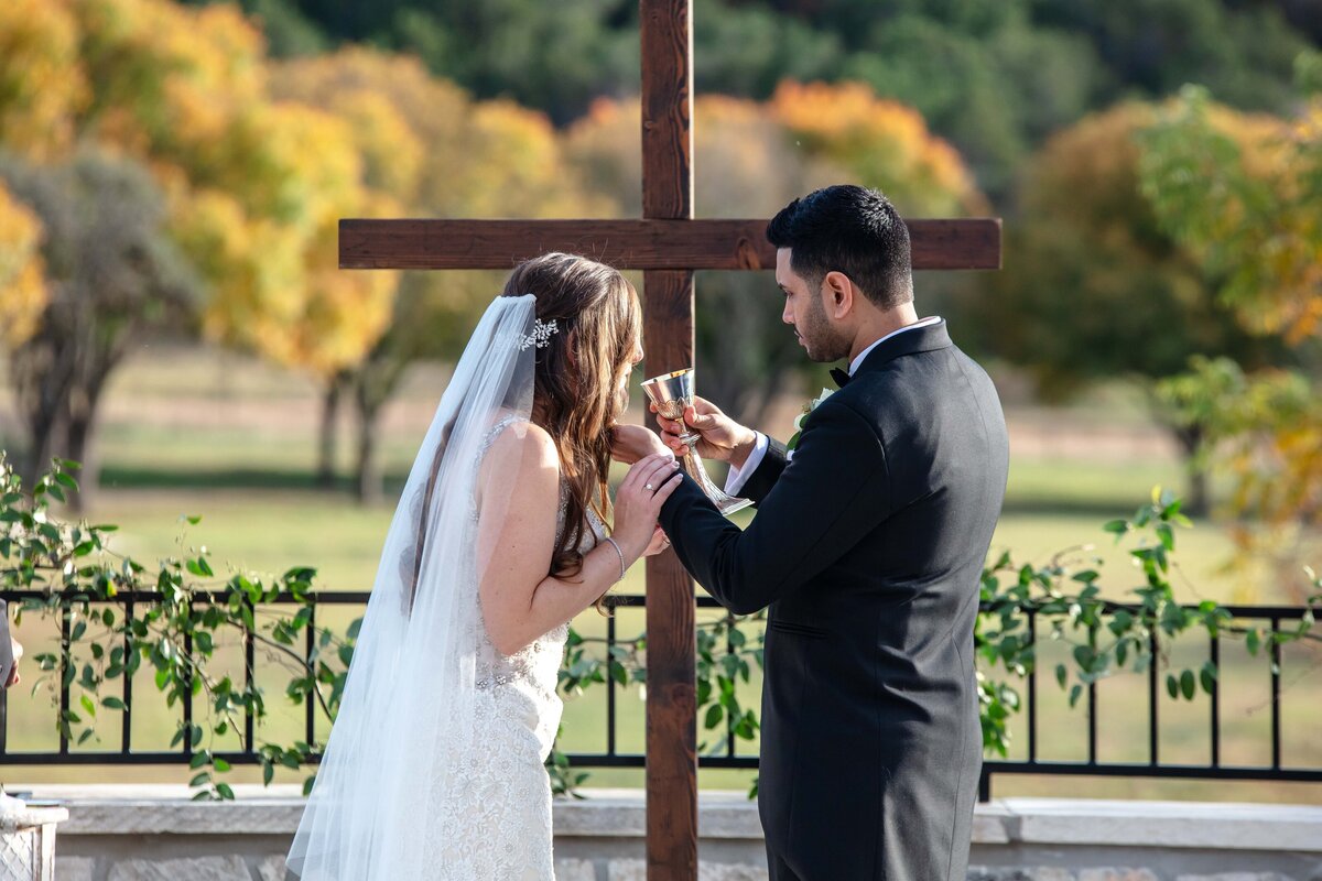groom gives bride a drink during communion ceremony at Sendera Springs wedding in Kerrville Texas