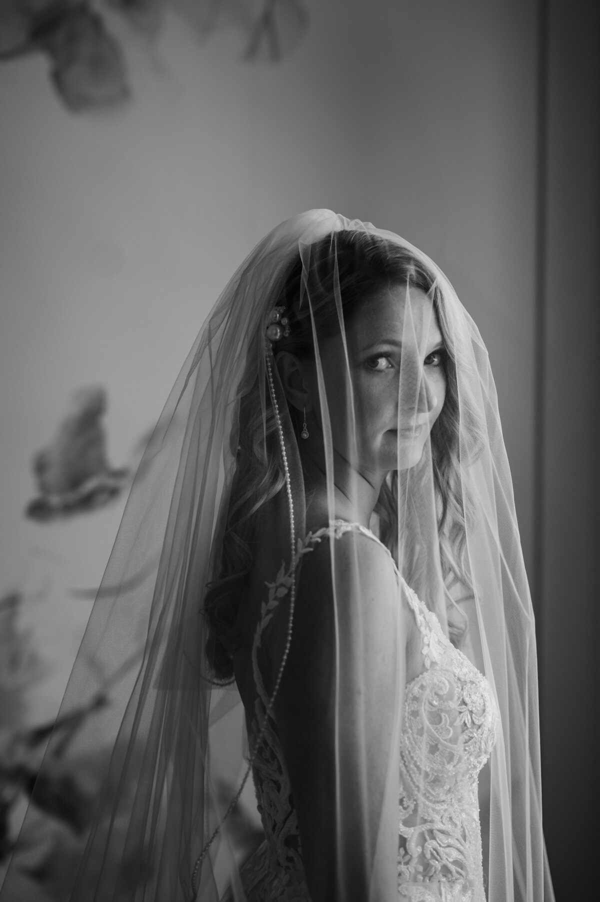 Bride standing next to window under veil