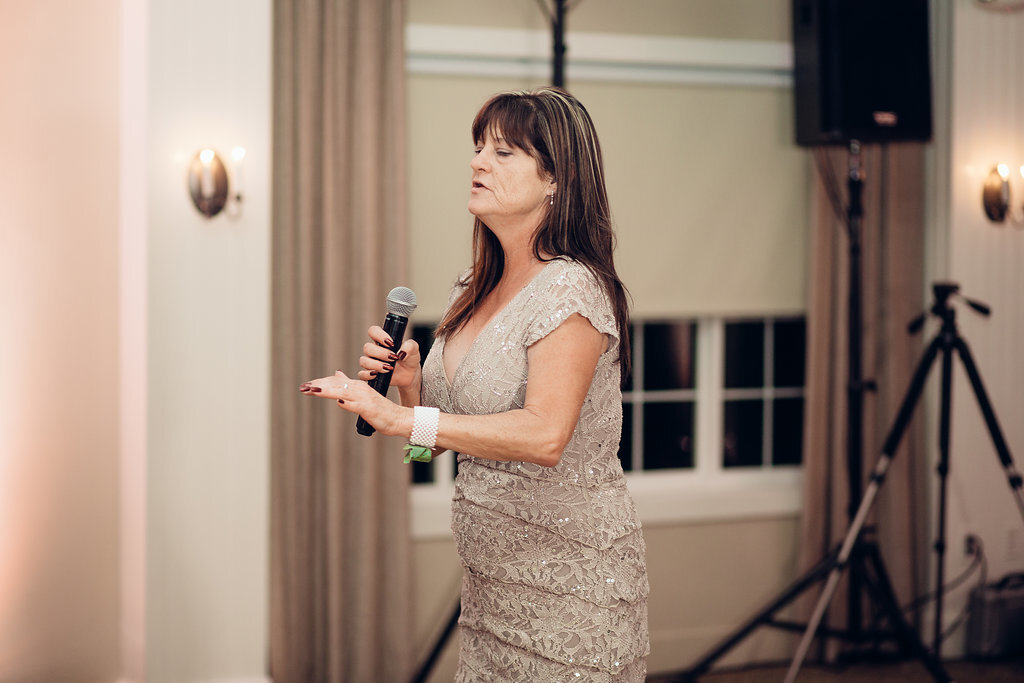 Wedding Photograph Of Woman In Light Brown Dress Speaking In Microphone Los Angeles