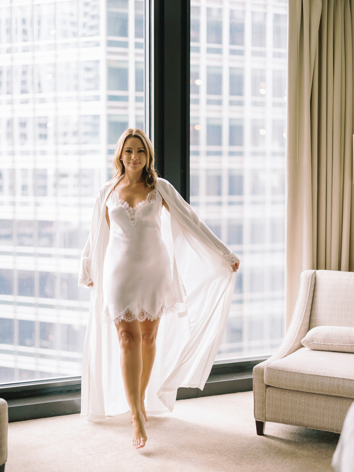 A woman wears a dramatic robe during her boudoir photo session