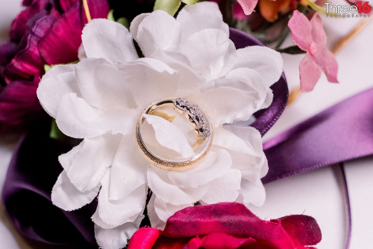Bride's rings sit on her bouquet of flowers