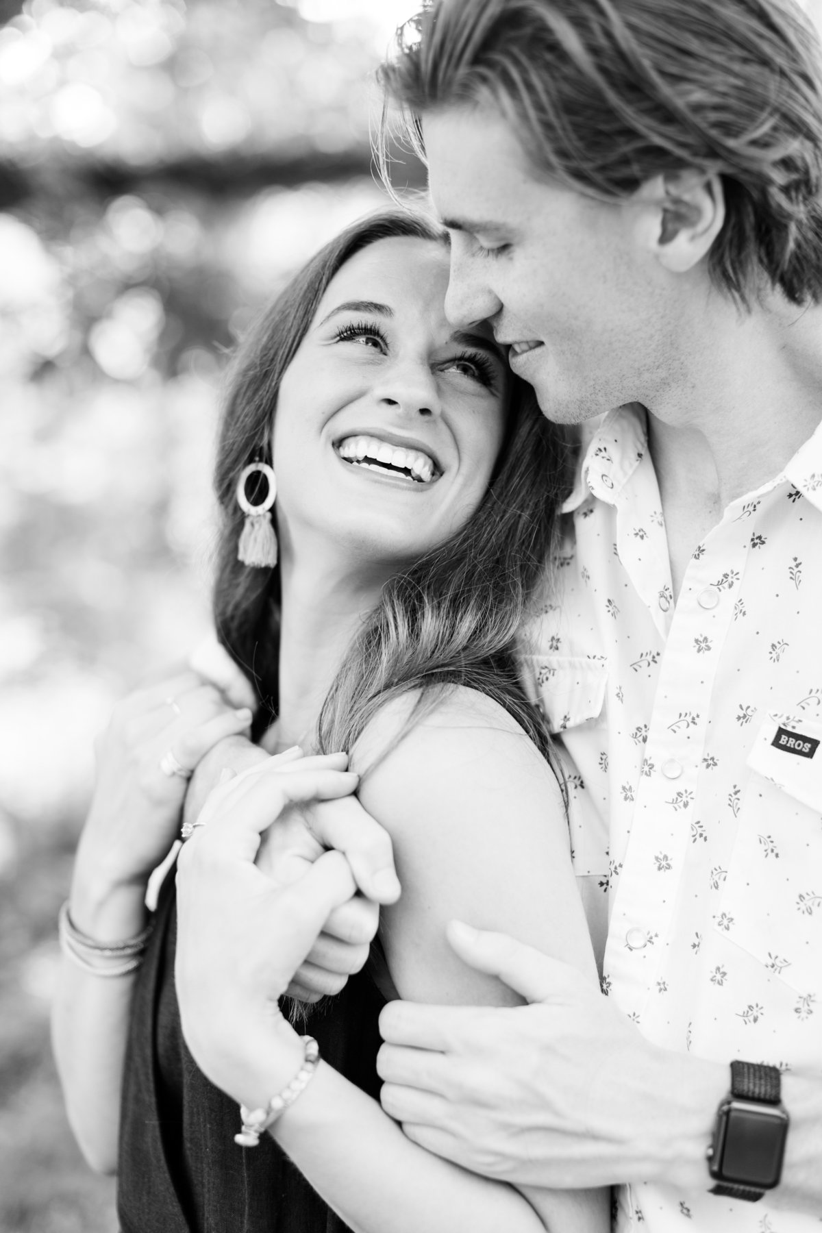 Black and white engagement photo of couple embracing