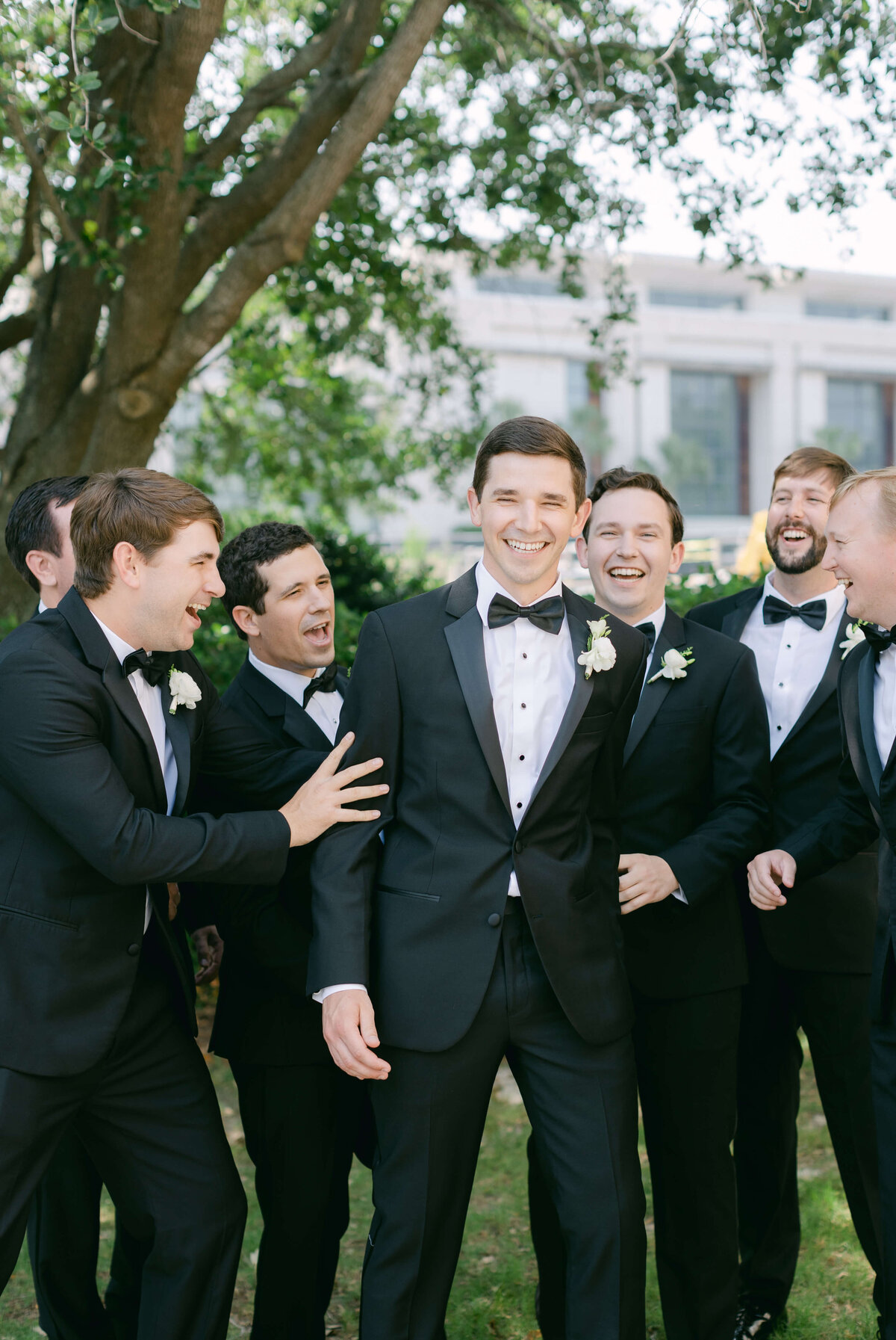 A groom laughs with his groomsmen.