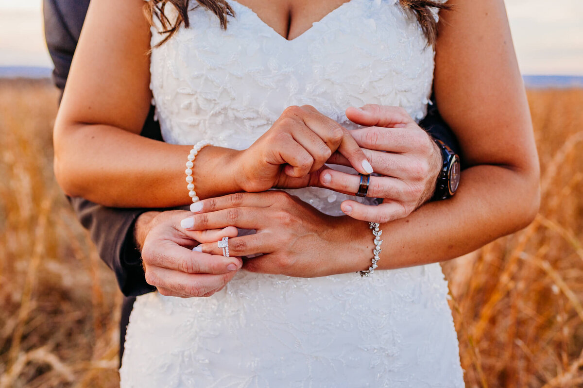 Photo of a bride and groom putting on each other's wedding rings