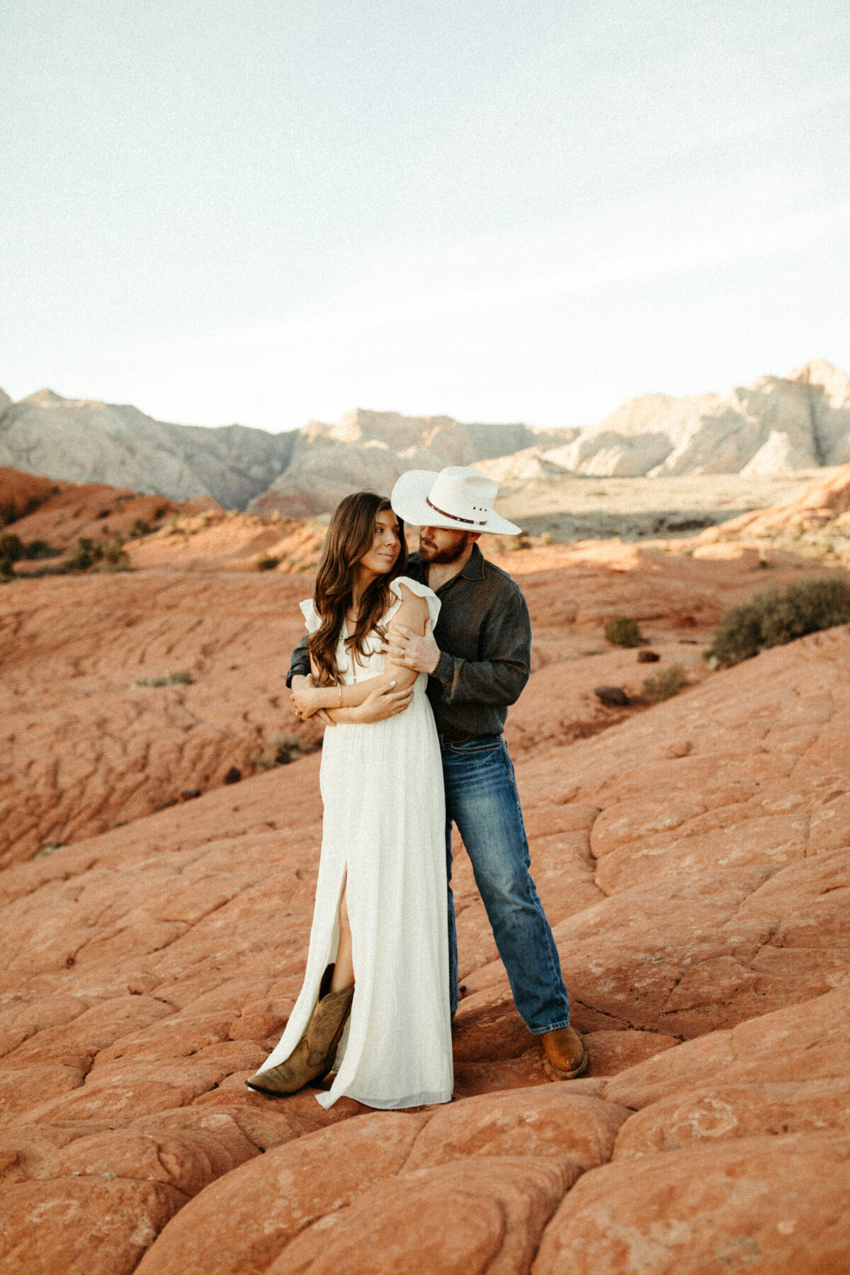 Guy wrapping his arm around his wife during their anniversary session at Snow Canyon State Park