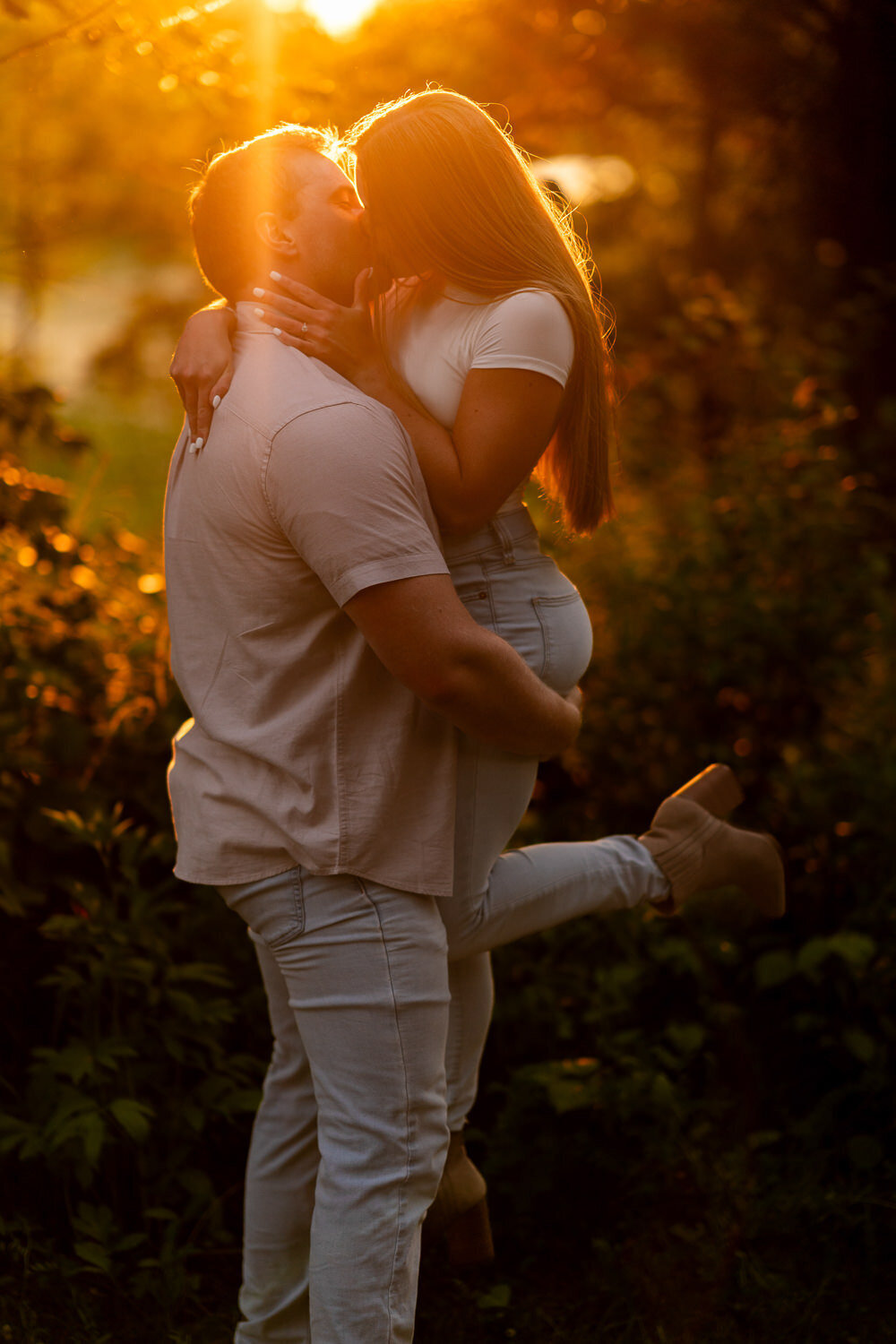 Man and woman kiss during golden hour in Eagan, Minnesota.