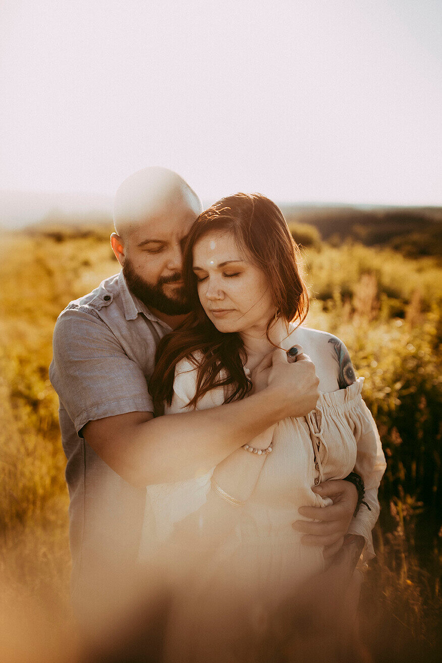 couple holding each other in a field