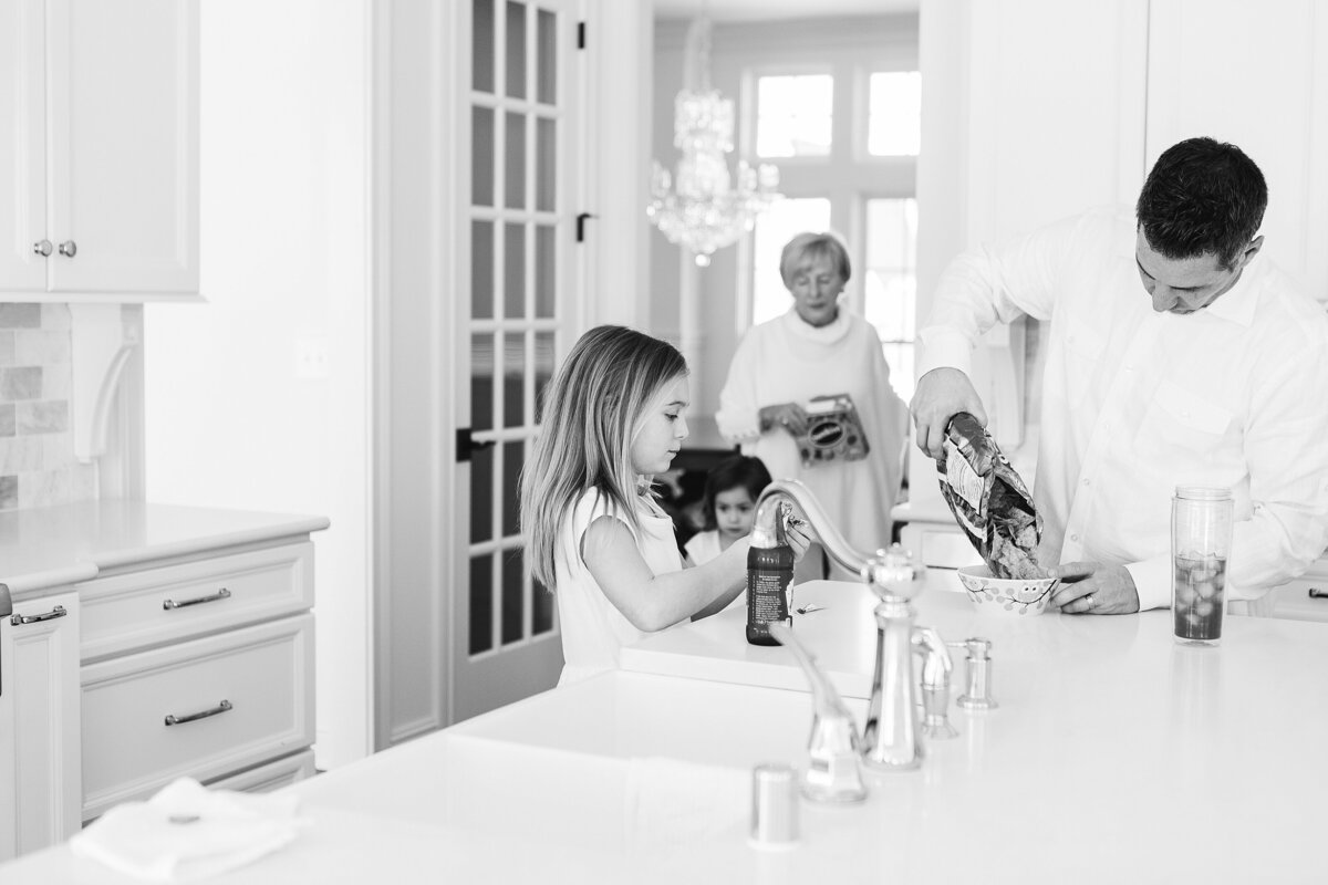 A black and white image of a family getting snacks during a lifestyle photo session in Lexington KY.